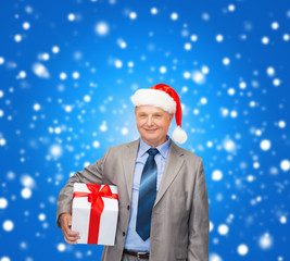 smiling man in suit and santa helper hat with gift