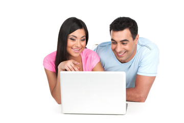 Smiling Indian couple looking together at laptop.