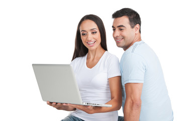 Indian loving  couple looking at white laptop.