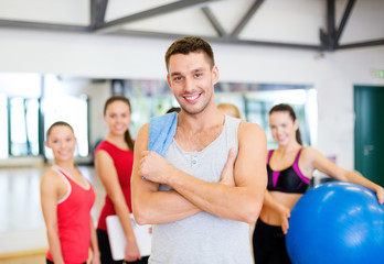 smiling man standing in front of the group in gym