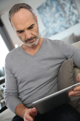 Mature man at home websurfing on internet