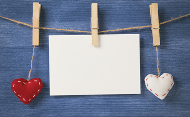 decorative hearts hanging on the rope against blue wood wall