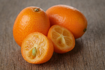 ripe kumquat fruits on wooden table