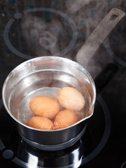 simmering chicken eggs in metal pot