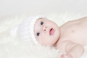 baby in white knitted hat