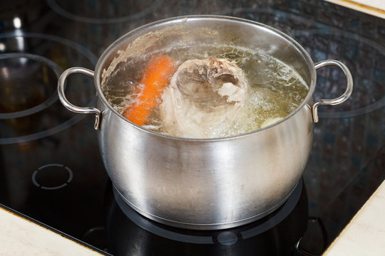 simmering chicken soup with seasoning vegetables