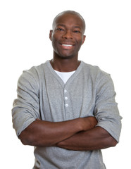 Laughing african man with in a grey shirt with crossed arms