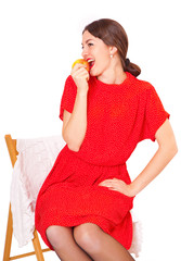 Woman eating an apple sitting on a chair