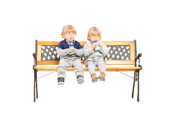 Brother and sister siblings sitting on a wooden bench and drinki