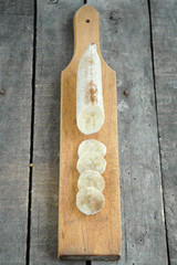 Peeled and sliced banana with cinnamon on cutting board