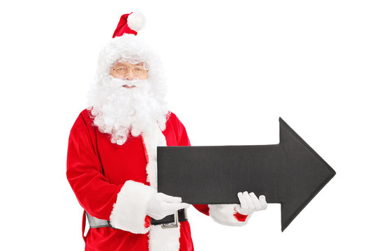 Smiling Santa Claus Holding A Big Black Arrow Pointing Right