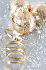 Obraz na płótnie Canvas golden christmas balls with golden streamer and snow decoration