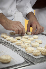 Chef adjust row of macaroon on tray