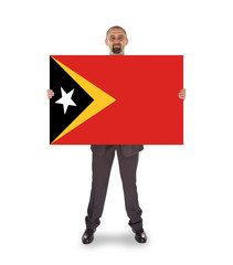 Smiling businessman holding a big card or flag