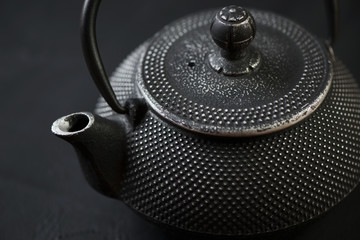 Obraz na płótnie Canvas Horizontal shot of black asian cast-iron teapot, close-up