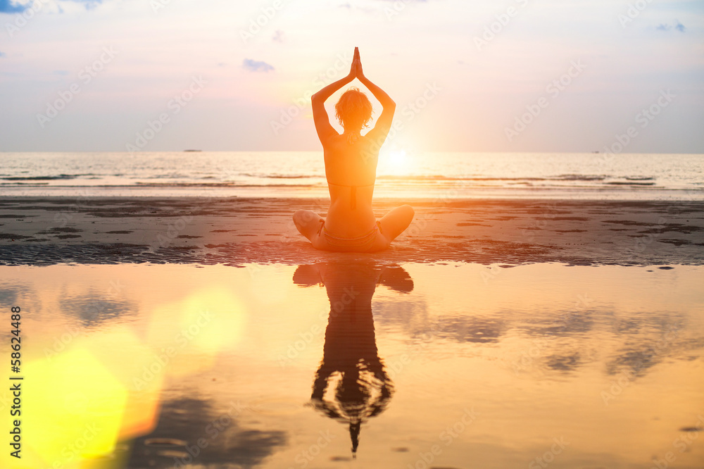 Wall mural Yoga, harmony of health, silhouette young woman on the beach