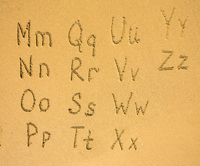 Alphabet (M-Z) written on a sand beach.