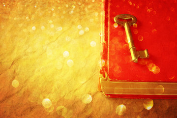 red book and vintage key and golden glitter lights