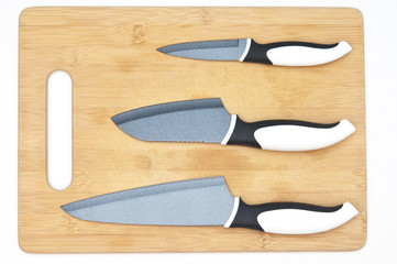 Kitchen knifes on wooden board closeup