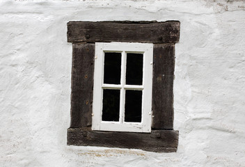 Old window on a white wall of house