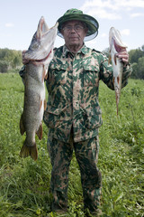 Naklejka premium A fisherman caught a pike