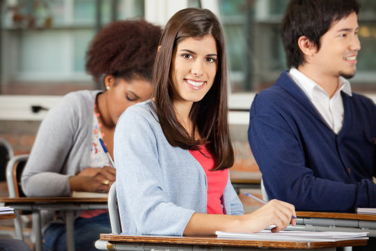 Student Sitting At Desk With Classmates In Classroom