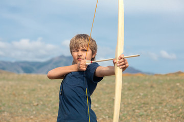 Boy shoots a bow at a target