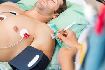 Obraz na płótnie Canvas Nurse Injecting Syringe On Patient's Arm In Hospital