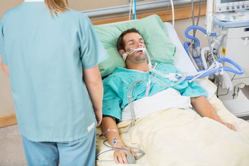 Patient Sleeping With Nurse Standing By
