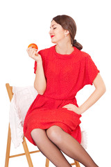 Woman holding an apple sitting on a chair