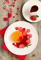 Orange terrine with strawberry sauce and strawberries.