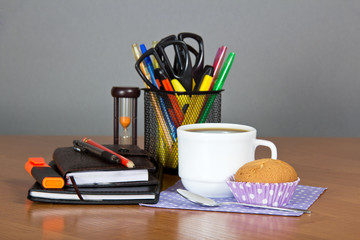 Office supply in support and cup of coffee