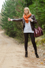 Pretty girl hitchhiking in the forest
