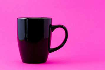Black mug on a pink background