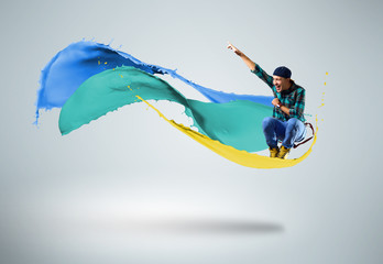 young male dancer jumping with splash of paint