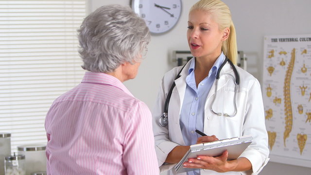 Female doctor taking patient history of elderly woman
