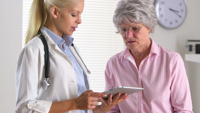 Female doctor talking to patient using tablet computer