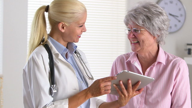 Smiling patient listening to doctor with tablet computer