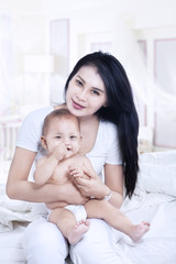 Fototapeta na wymiar Asian mother hug baby boy at home