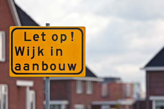 Road sign with Dutch text houses under construction