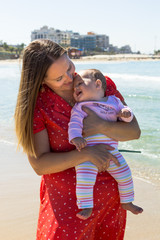 Mother and cute little baby girl on the beach