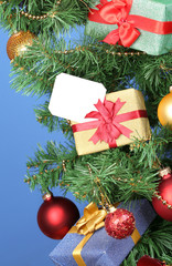 Fototapeta na wymiar Gifts on Christmas tree on color background