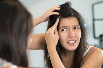 Horrified young woman looking in the mirror