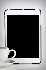 Tablet computer with white cup of coffee isolated on white backg