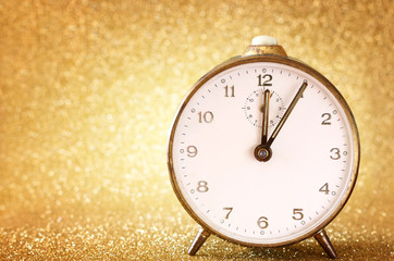 Fototapeta na wymiar vintage clock with glittering golden background