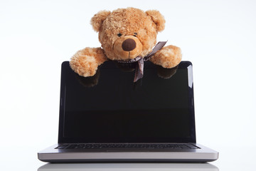 Fluffy toy bear and a laptop