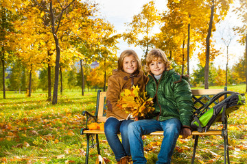 Two kids with bouquet of maple leaves