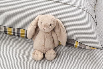 stuffed animal on cozy bed - obrazy, fototapety, plakaty
