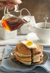 Stack of pancakes with butter and maple syrup