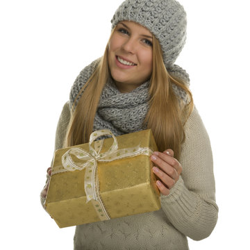 Warm angezogene Frau hält ein Geschenk und ist glücklich